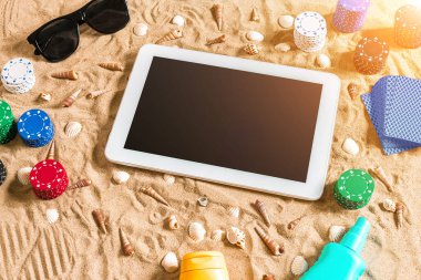 Tatil kavramı - beyaz kum deniz kabuklarını, renkli poker fişleri ve kartları ile kumar. Üstten Görünüm. Uzay kopyalayın. Yaz. Güneş parlaması