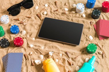 Tatil kavramı - beyaz kum deniz kabuklarını, renkli poker fişleri ve kartları ile kumar. Üstten Görünüm. Uzay kopyalayın. Yaz