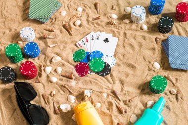 Tatil kavramı - beyaz kum deniz kabuklarını, renkli poker fişleri ve kartları ile kumar. Üstten Görünüm. Uzay kopyalayın. Yaz