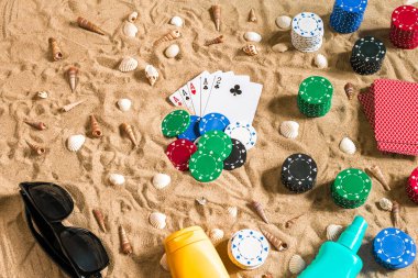Tatil kavramı - beyaz kum deniz kabuklarını, renkli poker fişleri ve kartları ile kumar. Üstten Görünüm. Uzay kopyalayın. Yaz