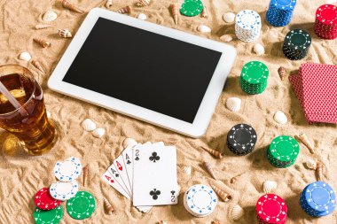 Tatil kavramı - beyaz kum deniz kabuklarını, renkli poker fişleri ve kartları ile kumar. Üstten Görünüm. Uzay kopyalayın. Yaz