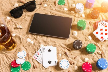 Tatil kavramı - beyaz kum deniz kabuklarını, renkli poker fişleri ve kartları ile kumar. Üstten Görünüm. Uzay kopyalayın. Yaz. Güneş parlaması