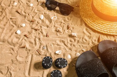 Plaj pokeri. Çipler kumda. Deniz kabuklarının, güneş gözlüklerinin ve parmak arası terliklerin etrafında. Üst Manzara. Uzayı kopyala Düz yatıyordu. Güneş parlaması