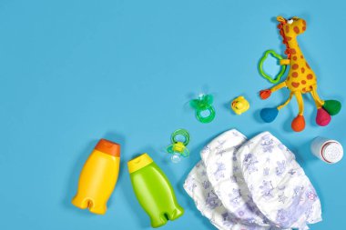 Banyo takımlı bebek bakımı. Meme ucu, oyuncak, bebek bezi, mavi arka planda şampuan. Düz yatıyordu. Durgun hayat. Boşluğu kopyala