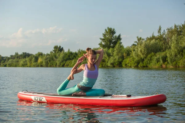 年轻女子用桨在船上做瑜伽 冥想姿势 侧面观点 与自然和谐相处的概念 自由健康的生活 自由职业 遥远的商业 — 图库照片