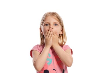Close-up portrait of a charming blonde little girl with a long hair, in a pink t-shirt, kissing her hands and looking at the camera while posing isolated on white background with copy space. Concept