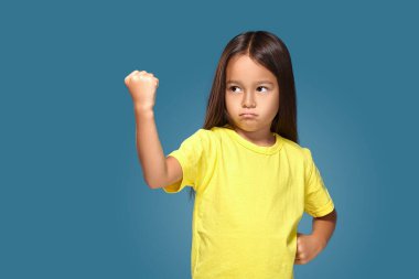 Angry little kid showing frustration and disagreement on blue background