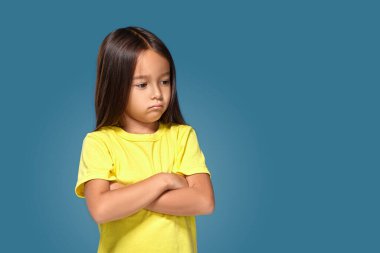 Angry little kid showing frustration and disagreement on blue background