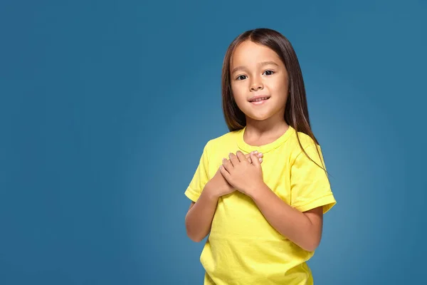 Κοριτσάκι Κίτρινο Μπλουζάκι Χέρια Στην Καρδιά Της Στο Μπλε Φόντο — Φωτογραφία Αρχείου