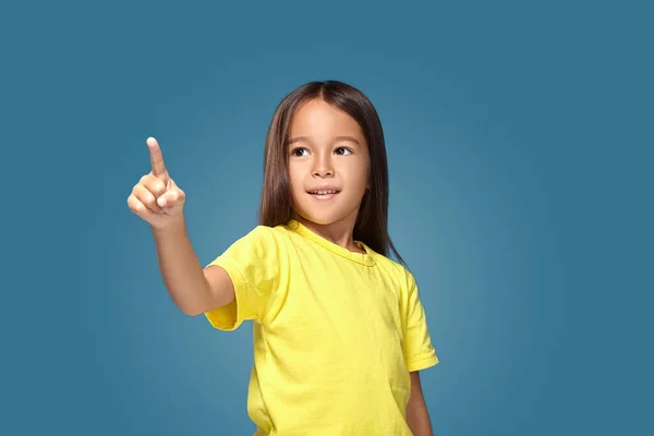 Cute Girl Shows Her Finger Blue Background — Stockfoto