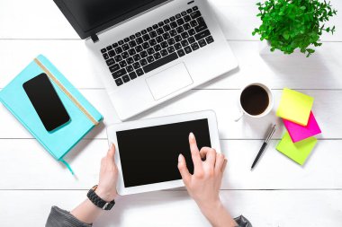Hand use white tablet on desk table top view. Copy space. Flat lay