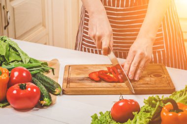 Genç kadın evde mutfakta yemek. Sağlıklı gıda. Diyet. Diyet kavramı. Sağlıklı bir yaşam tarzı. Evde yemek. Yemek hazırlamak. Bir kadın bir biber ve sebze bıçakla keser.