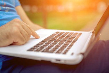 Yakın çekim yakışıklı kadeh dizüstü bilgisayar ekran dokunmadan eller mans. Dizüstü bilgisayar kullanan ve yerde oturan işadamı... Güneş parlaması