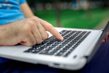 Yakın çekim yakışıklı kadeh dizüstü bilgisayar ekran dokunmadan eller mans. Dizüstü bilgisayar kullanan ve yerde oturan işadamı.