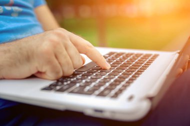 Yakın çekim yakışıklı kadeh dizüstü bilgisayar ekran dokunmadan eller mans. Dizüstü bilgisayar kullanan ve yerde oturan işadamı... Güneş parlaması