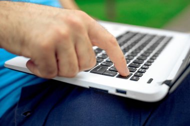 Yakın çekim yakışıklı kadeh dizüstü bilgisayar ekran dokunmadan eller mans. Dizüstü bilgisayar kullanan ve yerde oturan işadamı.