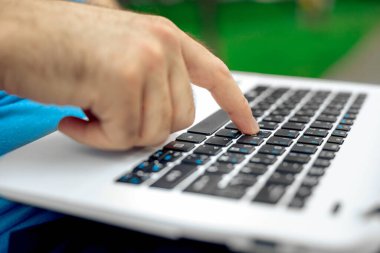 Yakın çekim yakışıklı kadeh dizüstü bilgisayar ekran dokunmadan eller mans. Dizüstü bilgisayar kullanan ve yerde oturan işadamı.