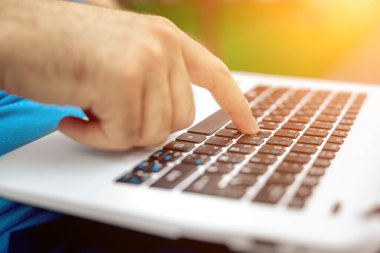 Yakın çekim yakışıklı kadeh dizüstü bilgisayar ekran dokunmadan eller mans. Dizüstü bilgisayar kullanan ve yerde oturan işadamı... Güneş parlaması