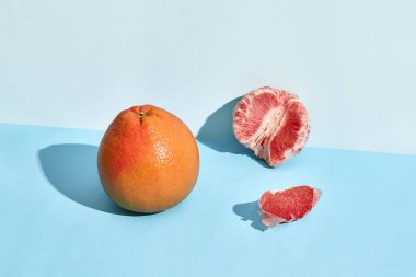 Grapefruit citrus fruit with half on blue background