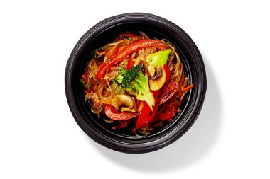 Bir kase lezzetli kızarmış pirinç eriştesi brokoli, dolmalık biber ve mantar, beyaz arka planda izole edilmiş üst manzara. Geleneksel Asya vejetaryen yemeği. Orijinal mutfak.