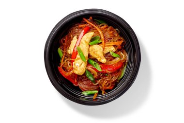 Baharatlı pirinç eriştesi, kızarmış tavuk filetosu, dolmalık biber ve havuçla pişirilmiş kolay karıştırılmış kızartma sosu, doğranmış yeşil soğanla servis ediliyor, beyaz arka planda izole edilmiş. Çin mutfağı.