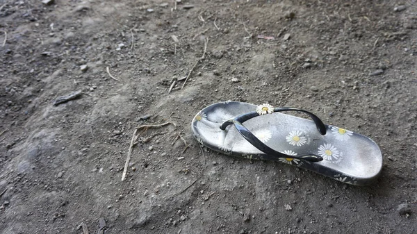 Eski terliklerden biri yerde yatıyordu..