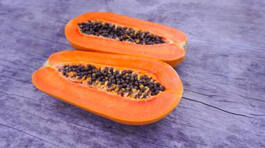 Olgun papaya, tahta zeminde ikiye bölünmüş, sağlıklı meyve, yüksek vitamin, iyi vejetaryen yemeği..