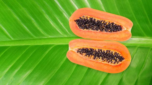 熟したパパイヤ 半分にカット 緑の葉に置く ビタミンが高い 健康のための菜食主義者の食べ物 — ストック写真