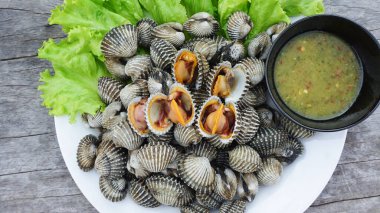 Beyaz tabakta taze midye, salatalı yüksek proteinli deniz ürünleri ve sağlıklı deniz ürünleri sosu..