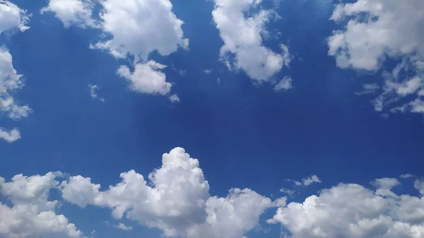 Yazın mavi gökyüzünün şehvetli beyaz bulutlu fotoğrafı.