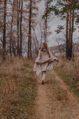 Sonbahar ormanında koşan kız
