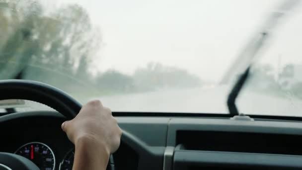 O motorista dirige o carro em chuva forte, vista através do pára-brisas do carro — Vídeo de Stock