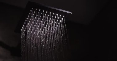 Duşta siyah kare bir hortumdan su akar..