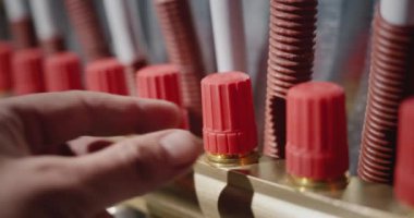 Bir adamın eli ısıyı zeminin altındaki ısıtma sistemindeki tarağa ayarlar.