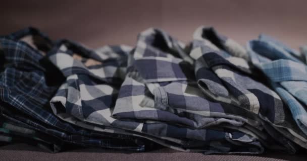 Nazikçe katlanmış gömlekler rafta yatıyor. Kaydırıcı atışı — Stok video