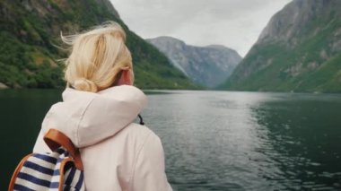 Bir yolcu gemisinin pruvasındaki kadın Norveç 'teki fiyorda hayran.