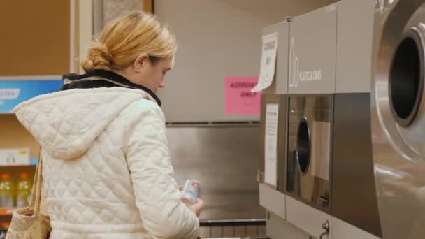 Локпорт, штат Нью-Йорк, США, октябрь 2021 года: женщина кладет банки с напитками в автомат. Она сканирует штрих-код и получает чек за доставку контейнера.. — стоковое видео