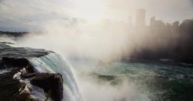 Niagara Şelalesi 'nin muhteşem manzarası. Sis duvarı Kanada kıyılarını kaplıyor. Nehrin çok altında bir tekne yüzüyor.