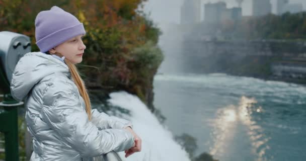 Een kind bewondert het spectaculaire landschap bij Niagara Falls. Staat aan de Amerikaanse kant met uitzicht op de Canadese kust — Stockvideo