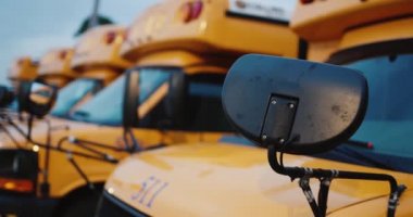 Okul çocuklarını taşımak için birkaç okul otobüsü. Araç parçalarının ve diğer araçların arka sıralarının yakın plan görüntüsü