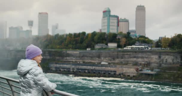 Het kind bewondert de Niagara rivier en de waterval, staat tegen de achtergrond van de Canadese kust — Stockvideo