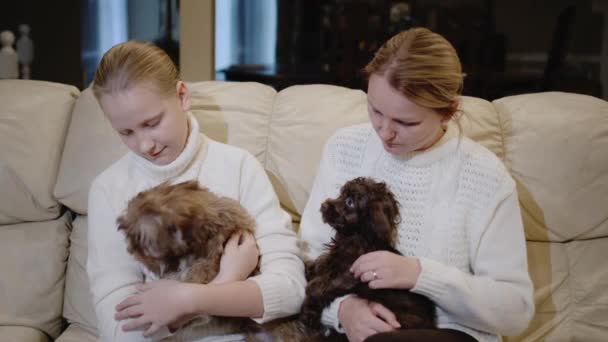 Mor och dotter leker tillsammans med små valpar, kopplar av hemma — Stockvideo