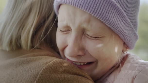 Ребенок плачет на плече матери, очень расстроен, слезы текут — стоковое видео