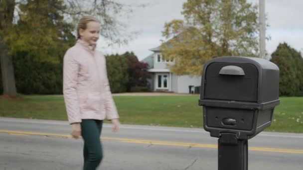 A child picks up letters from a street mailbox in a US suburb. — Stock Video