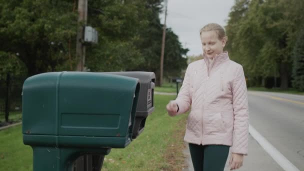 Een kind pikt brieven op uit een brievenbus in een buitenwijk van de VS. Zijaanzicht — Stockvideo