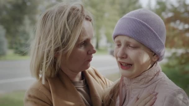 Una niña de diez años llora, su madre la calma — Vídeos de Stock