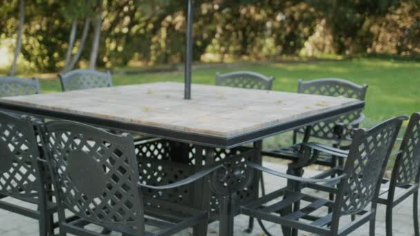 Las mesas vacías con las sillas levantadas - la terraza veraniega del café sin visitas — Vídeo de stock