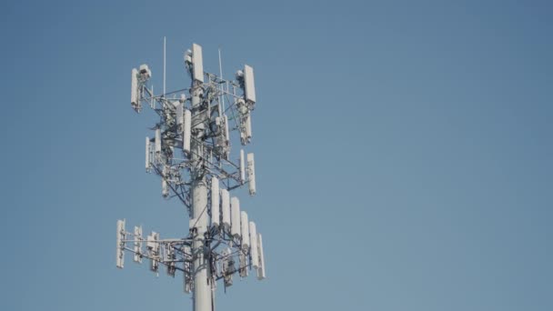 Mástil con antenas celulares contra un cielo azul — Vídeos de Stock