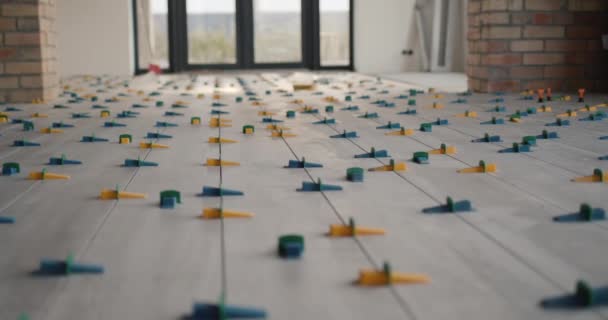 На підлогу будинку кладуть керамічну плитку, закріплену системою вирівнювання — стокове відео