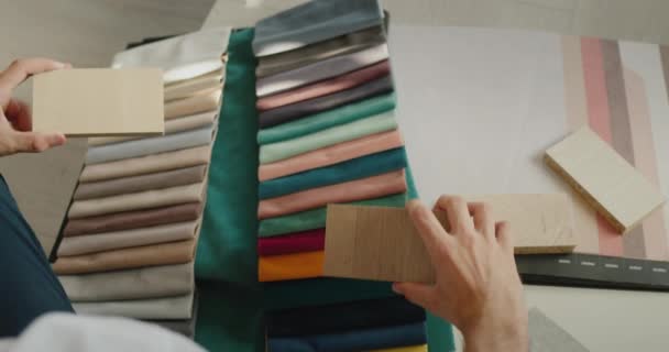 Top view: designer chooses finishing materials for repair and stylish interior, he has an album with samples of fabrics, wallpaper and wood samples — Video